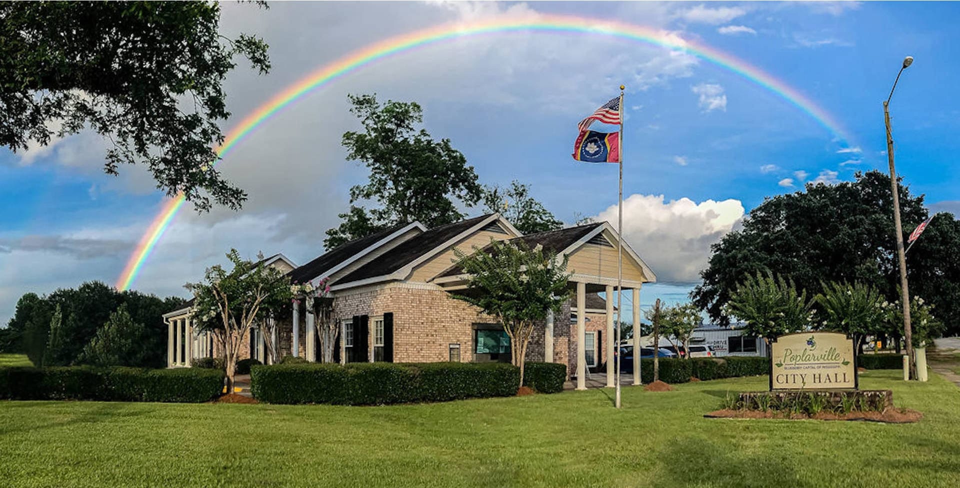 Poplarville City Hall on Highway 26 East with a full rainbow arching over the building.